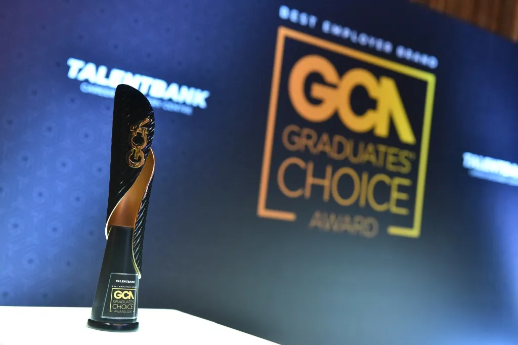 A Graduates’ Choice Award trophy on the stage table at the 2019 gala, with the award backdrop behind it